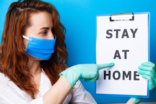 Женщина держит пустой с надписью остаться дома, призывая прекратить распространение covid-19
 - Фото, изображение