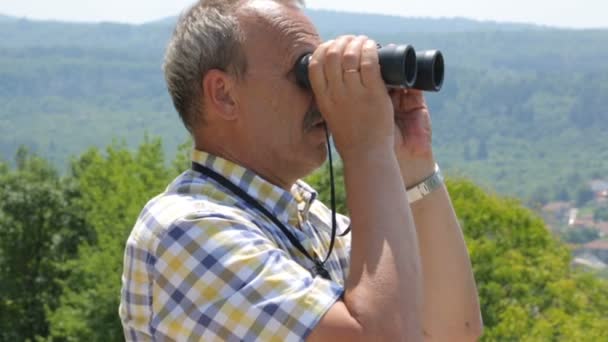 Turista masculino mirando a través de prismáticos
 - Imágenes, Vídeo