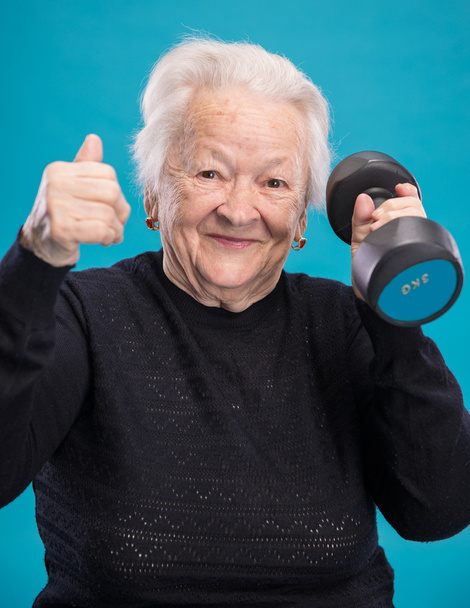 Felice vecchia donna che fa allenamento fitness con i manubri
 - Foto, immagini