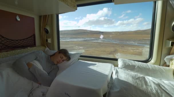 CERRAR: Chica cansada duerme en su camarote durmiente durante el viaje en tren a través del Tíbet. - Metraje, vídeo