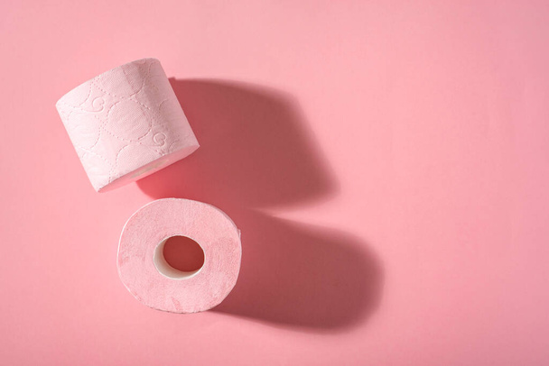 Dwie rolki różowego papieru toaletowego na różowym tle. Produkty higieniczne. Widok góry. Przestrzeń kopiowania. - Zdjęcie, obraz