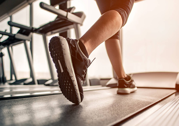 Nahaufnahme auf dem Schuh, Frauen laufen in einem Fitnessstudio auf einem Laufband. Trainingskonzept. Fitness und gesunder Lebensstil  - Foto, Bild