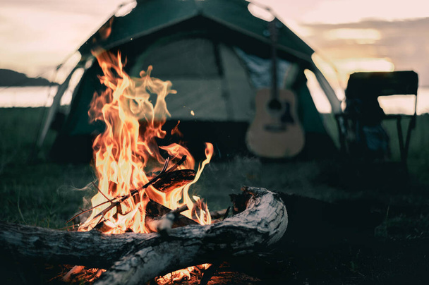 Group of friends camping.They are sitting around fire camp. - 写真・画像