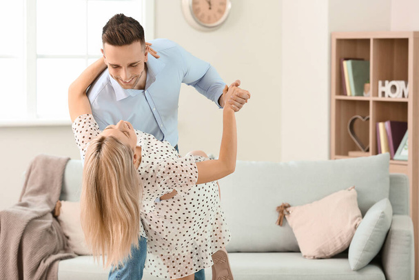 Happy dancing young couple at home - Foto, Bild