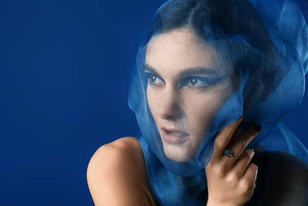 Portrait of fashionable young woman with veil on blue background - Zdjęcie, obraz