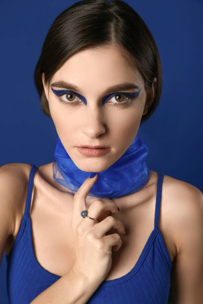Πορτρέτο της μόδας νεαρή γυναίκα με πέπλο σε μπλε φόντο - Φωτογραφία, εικόνα