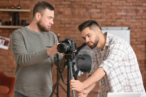 Mentor geeft les aan jonge fotografen in studio - Foto, afbeelding