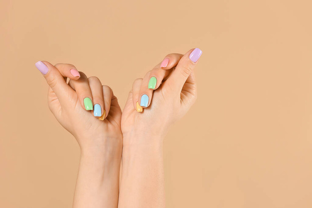 Handen van jonge vrouw met mooie manicure op kleur achtergrond - Foto, afbeelding