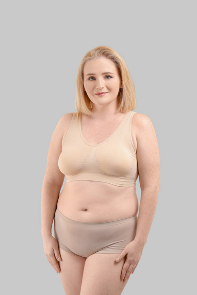 Sovrappeso donna su sfondo grigio
 - Foto, immagini