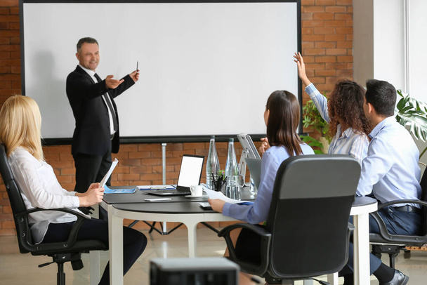 Mature businessman giving presentation during meeting in office - Photo, Image