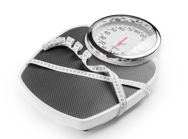 Ваги з вимірювальною стрічкою на білому тлі. концепція схуднення
 - Фото, зображення