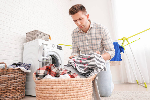 Troubled man doing laundry in bathroom - Photo, image