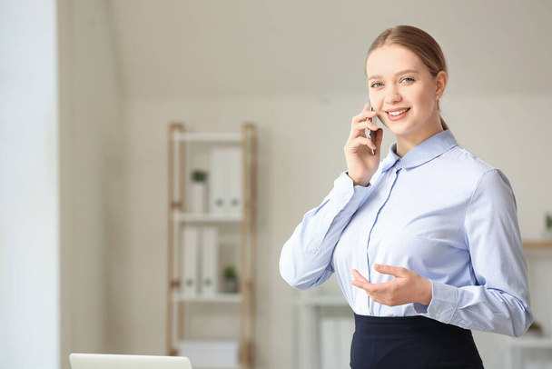 Portrait de jeune femme d'affaires parlant par téléphone au bureau
 - Photo, image