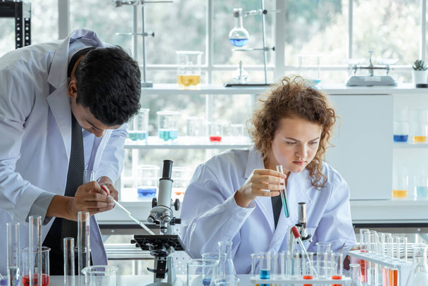 Исследователи в белых халатах, работающих в современной биологической лаборатории. - Фото, изображение