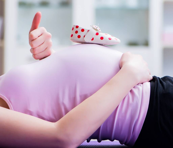 Terhes nő, aki a szülésre való felkészülésben gyakorol - Fotó, kép