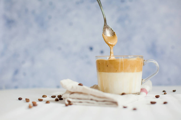 Холодный кофе Далгона в стакане. Модный пушистый сливочный взбитый кофе. Кофе на белом фоне
 - Фото, изображение