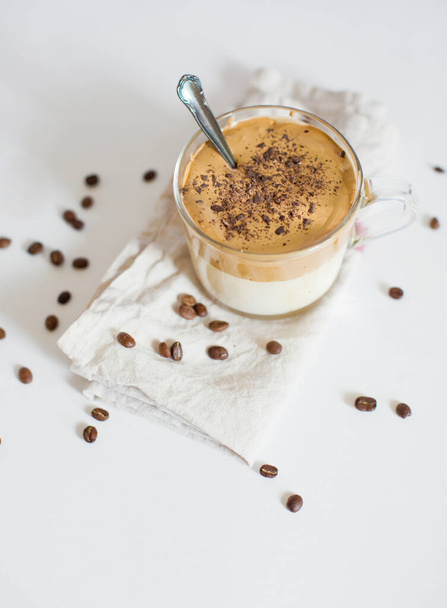 Iced Dalgona Coffee in a glass cup. Trendy fluffy creamy whipped coffee. Coffee on a white background - Foto, afbeelding