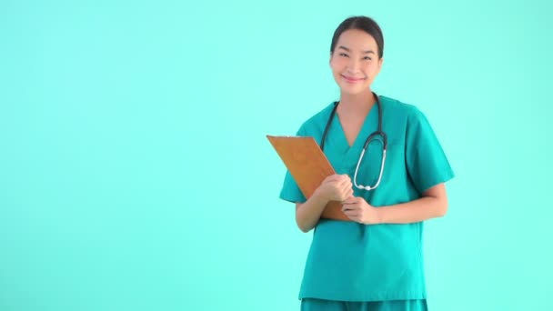 Portrait belle jeune asiatique médecin femme avec presse-papiers sur fond bleu isolé
 - Séquence, vidéo