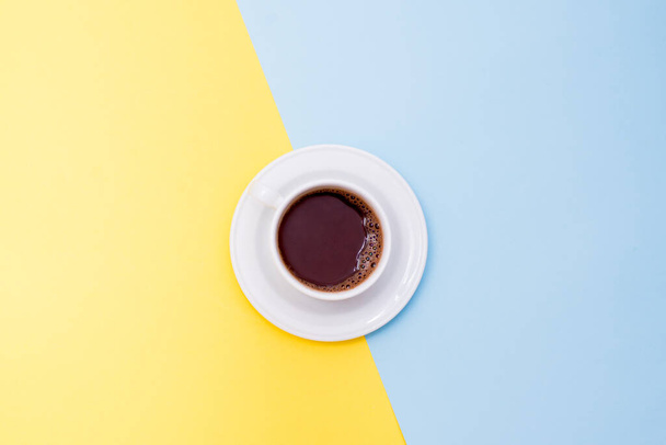 Filiżanka kawy na żółto-niebieskim tle z przestrzenią do kopiowania - Zdjęcie, obraz