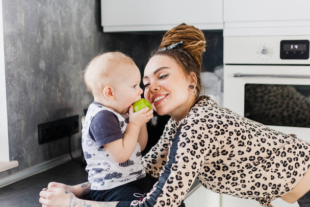 Anya és baba beszélgetés, otthon a konyhában, lány és raszta, alma, egészséges étel a gyermek, - Fotó, kép