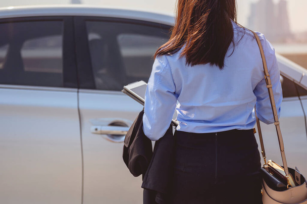 businesswoman, working, business, car, multitasking, technology concept. Close-up of the hand, Businesswoman opening the car door with coffee cup and laptop. - Фото, изображение