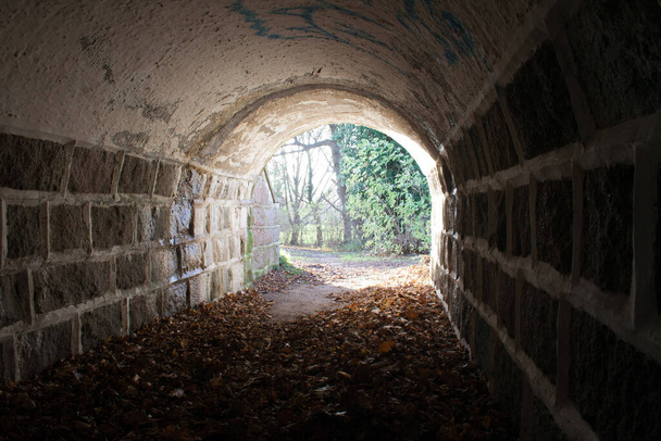 Túnel con luz al final, hay esperanza al final, túnel de pared de piedra. oscuro al principio
 - Foto, imagen