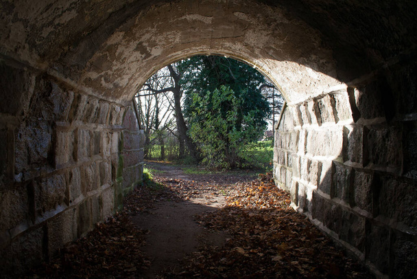 Fénnyel teli alagút a végén, van remény a végén, kőfal alagút. sötét az elején - Fotó, kép