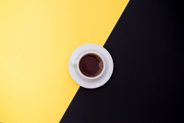 φλιτζάνι φρέσκο espresso σε κίτρινο και μαύρο φόντο, πάνω όψη με ένα χώρο αντίγραφο - Φωτογραφία, εικόνα