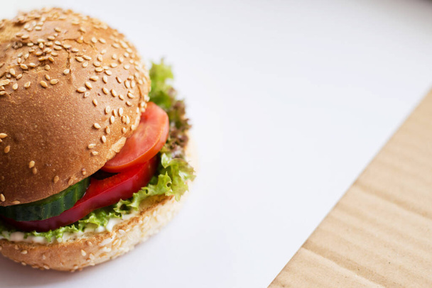Hamburger with beef, cheese and vegetables on rustic table. Closeup with copy space - Photo, Image