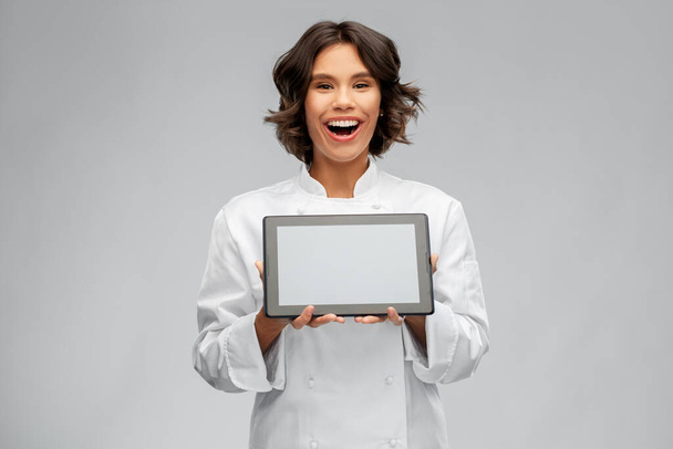 smiling female chef in toque with tablet computer - Valokuva, kuva