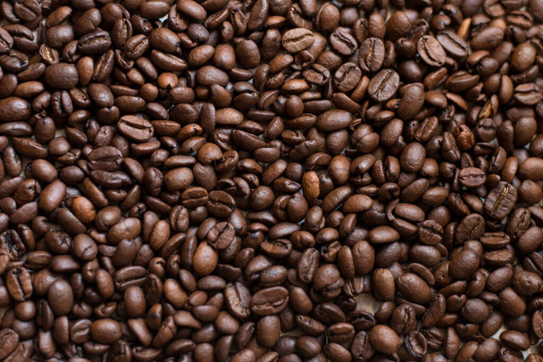Textuur van koffiebonen willekeurig verspreid. Bruine textuur. - Foto, afbeelding