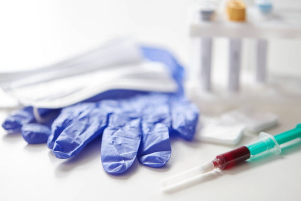 close up of blood in syringe, gloves and mask - Valokuva, kuva