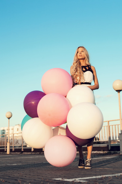Щаслива молода жінка з барвистими латексними кульками
 - Фото, зображення