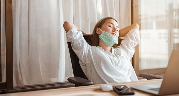Woman work from home wearing mask protection wait for epidemic situation to improve soon at home. Coronavirus, covid-19, Work from home (WFH), Social distancing, Quarantine, Prevent infection concept. - Photo, image