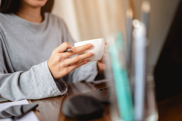 Woman holding a coffee cup work from home wait epidemic situation to improve soon at home. Coronavirus, covid-19, Work from home (WFH), Social distancing, Quarantine, Prevent infection concept. - Foto, Bild