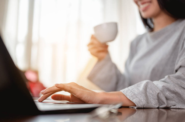 Woman holding a coffee cup work from home wait epidemic situation to improve soon at home. Coronavirus, covid-19, Work from home (WFH), Social distancing, Quarantine, Prevent infection concept. - Photo, image