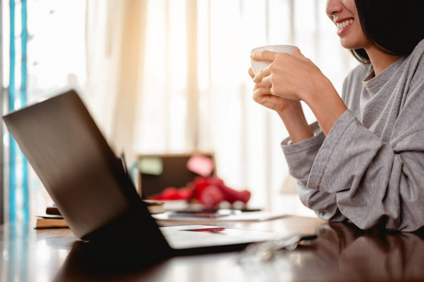 Woman holding a coffee cup work from home wait epidemic situation to improve soon at home. Coronavirus, covid-19, Work from home (WFH), Social distancing, Quarantine, Prevent infection concept. - Фото, зображення