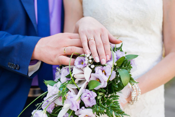 結婚式のカップル。花嫁の花束に手と指輪。愛の宣言だ。結婚式の背景、日の詳細 - 写真・画像