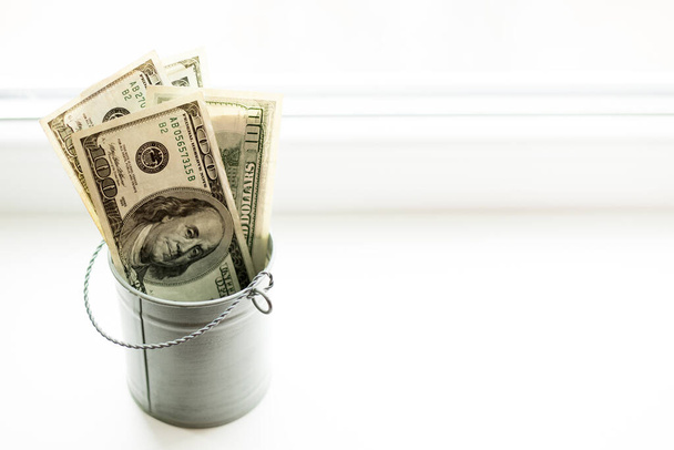Moneybox, dollars in bucket on white window.light background. place for text. top view. a lot of money - Foto, immagini