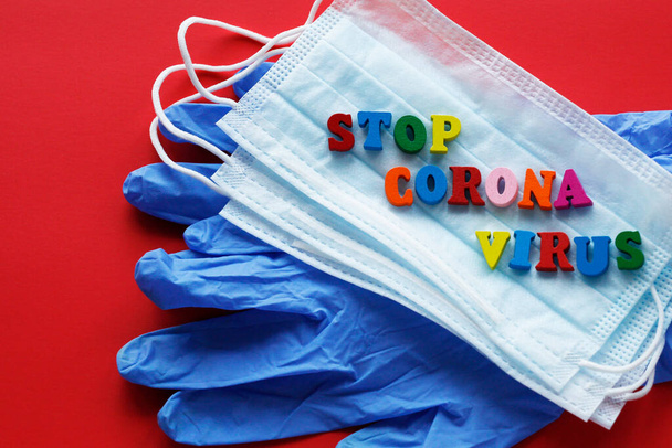 The words STOP CORONAVIRUS are written. On a red background there are latex gloves for hands and two medical masks. - Φωτογραφία, εικόνα
