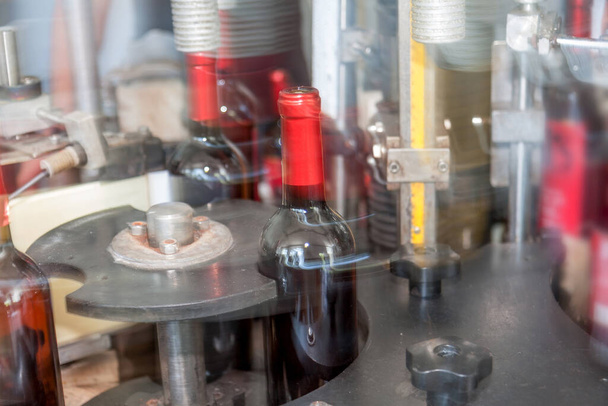 Výroba průmyslového dopravníkového pásu ve vinařství se skleněnými lahvemi v procesu práce a pohybu. Rozmazaný pohyb. Ne bez ostřeného pozadí pro průmyslový design - Fotografie, Obrázek