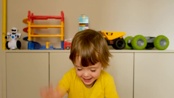 Roztomilý chlapec bubnování jeho ruce na povrchu - Záběry, video
