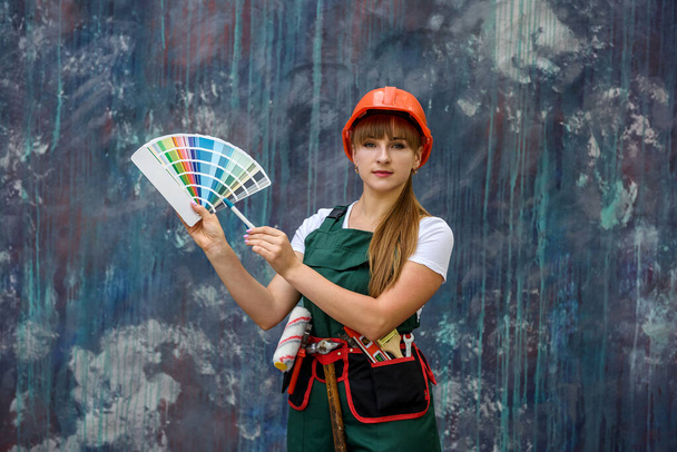 Женщина в защитной форме с цветными образцами позирует на абстрактном фоне
 - Фото, изображение