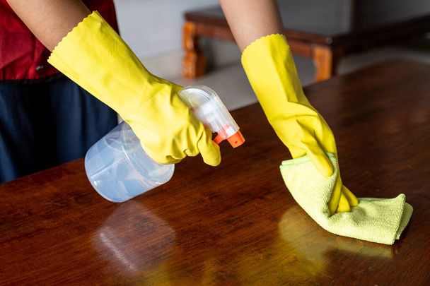 Les femmes de ménage ont utilisé un chiffon et une solution de nettoyage pour nettoyer la table et la chaise
. - Photo, image