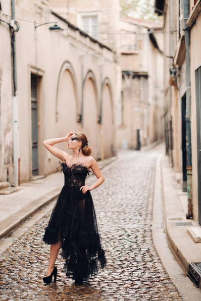 A stylish bride in a black wedding dress poses in the old French city of Avignon. Model in a black dress. The papal Palace in Avignon, Provence - Zdjęcie, obraz