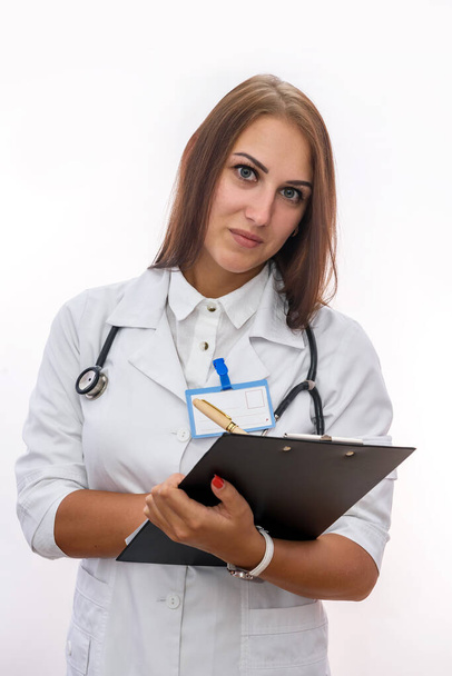 Doctor with clipboard. Pretty woman in medical uniform holding clipboard isolated on white - Fotó, kép