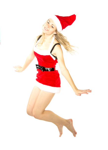 Happy smiling woman in red xmas costume jumping high - Photo, image