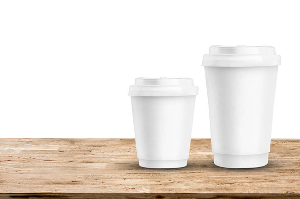 Бумажные кофейные чашки на светло-коричневом столе
 - Фото, изображение