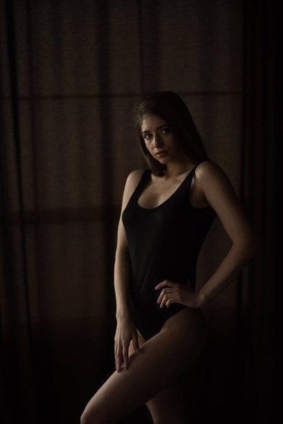 sexy Mädchen im schwarzen Körper auf dunklem Hintergrund - Foto, Bild