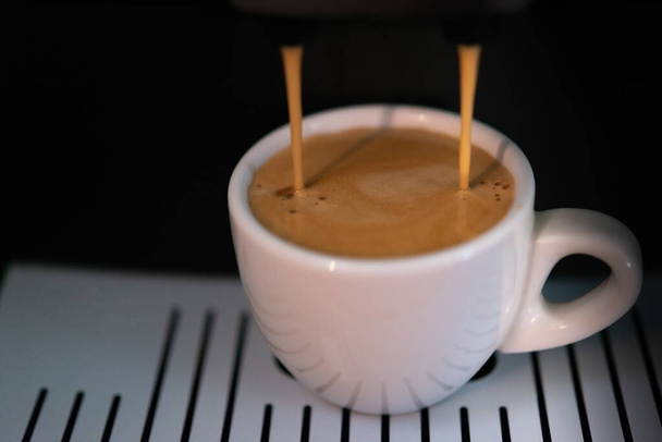 Cup of fresh espresso in a coffee machine - Zdjęcie, obraz